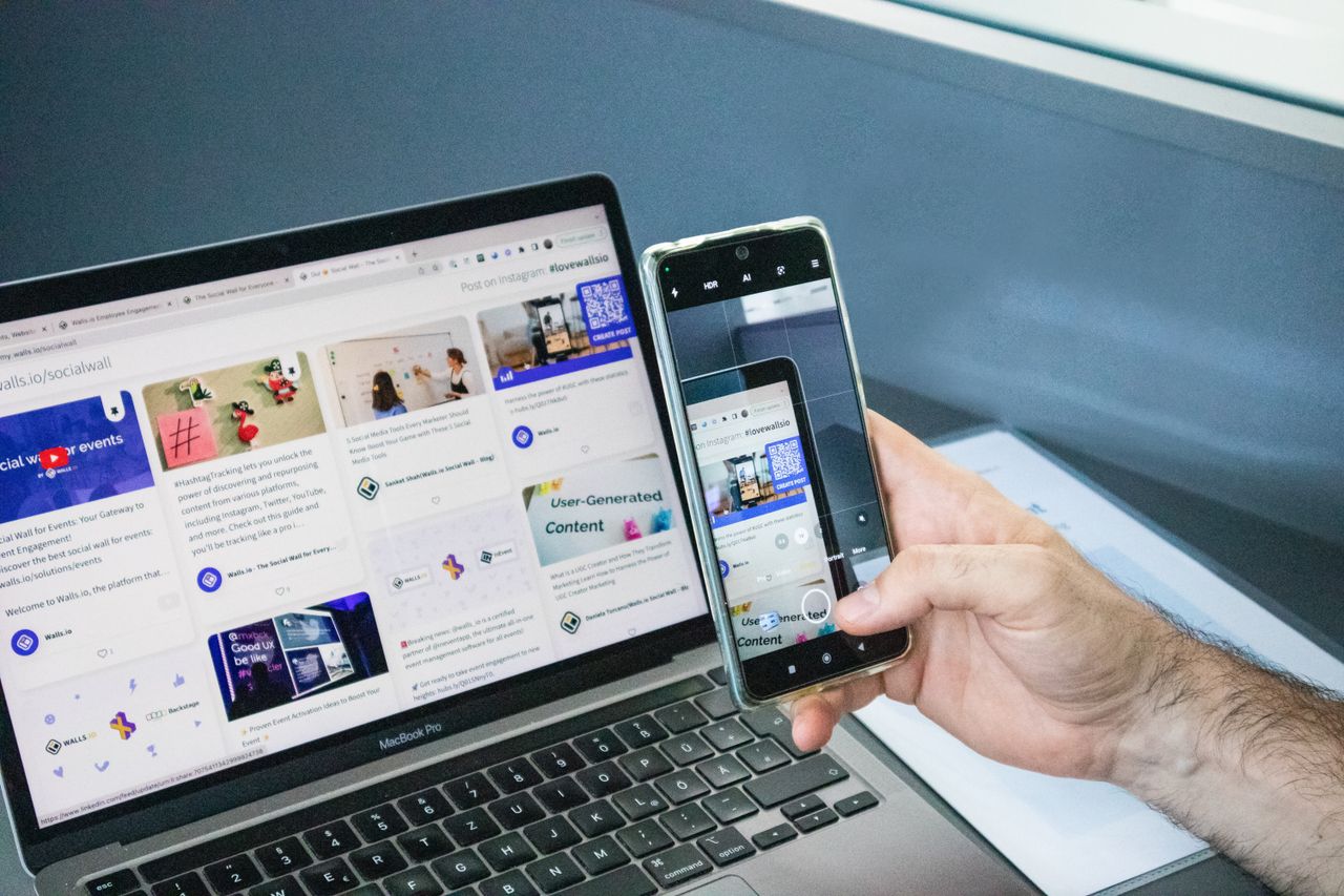 About Close-up of a smartphone capturing a laptop screen, representing technology integration.