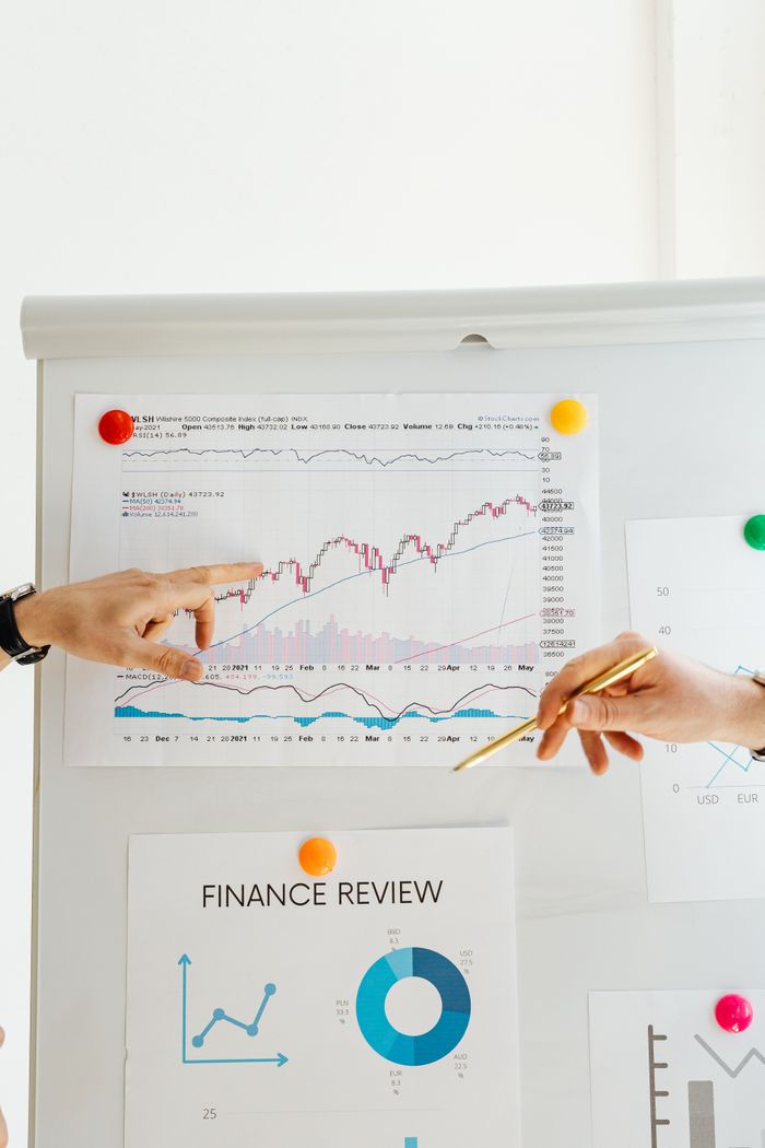About Hands pointing to financial charts during an office presentation.