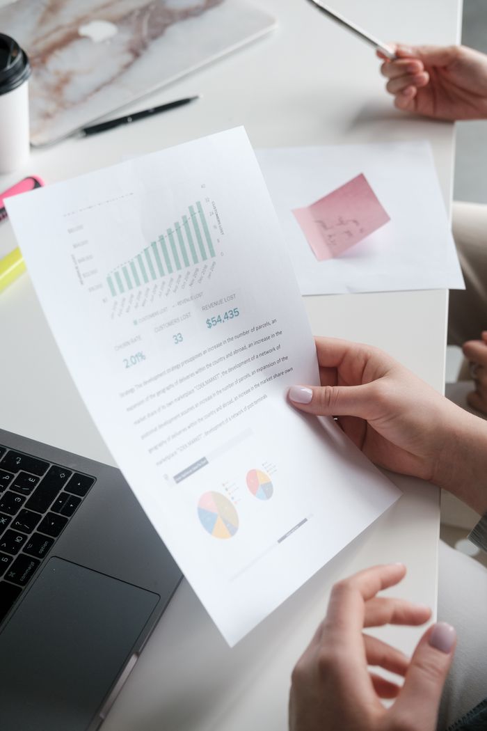 Mastering the First Impression: Your intriguing post title goes here Hands holding a business report with graphs, in a modern office setting.